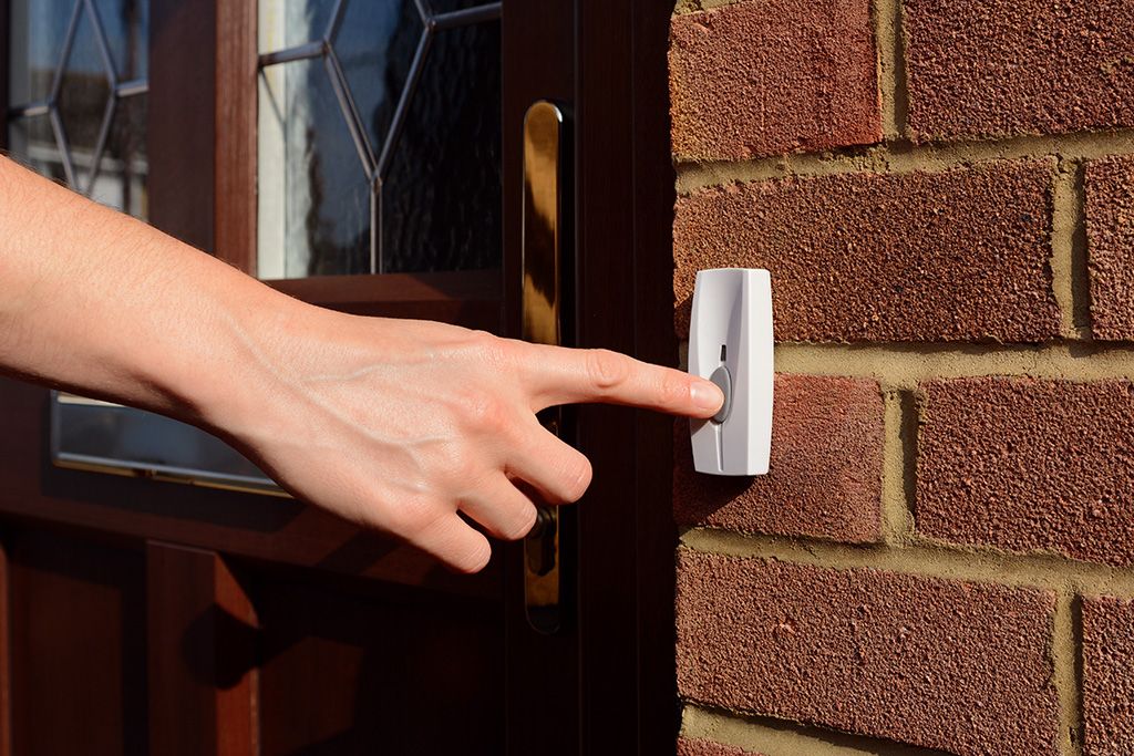 Nahaufnahme einer Hand, die auf einen weißen Klingelknopf drückt.  Das Foto steht symbolisch für die Erklärung des Begriffes Ambulant Betreutes Wohnen im WENDEPUNKT e.V.