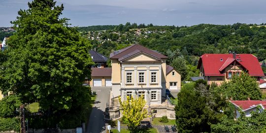 Drohnen-Aufnahme der Sozialpädagogischen Familienhilfe Sucht. Die modernisierte Villa ist umgeben von der grünen Landschaft des Saale-Holzland-Kreises.