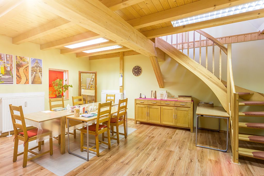 Blick auf den großen Holztisch, an dem die Klienten der Tagesstätte für Suchtkranke in Eisenberg im Rahmen der Ergotherapie die Kerzen kunstvoll verzieren.