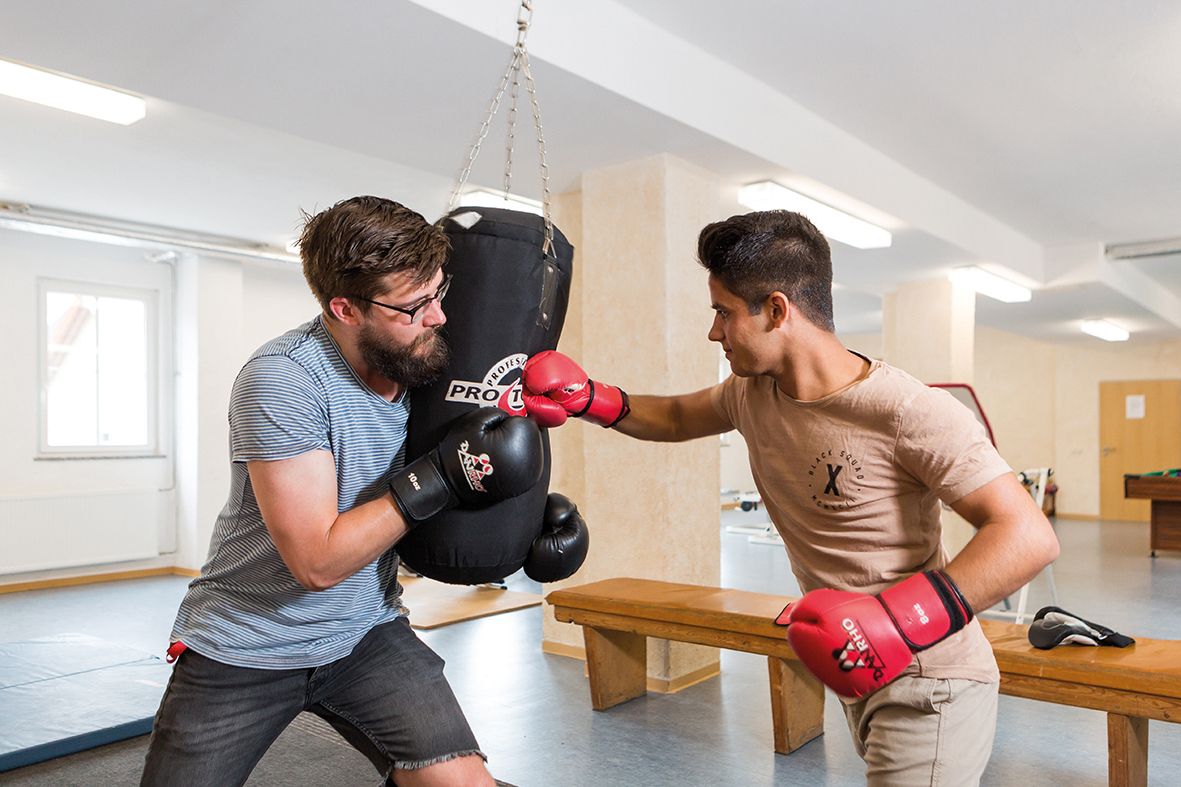 Symbolfoto für Stellenangebote: junger Mitarbeiter und ein Bewohner des Jugendhilfezentrums Wolfersdorf beim Boxtraining