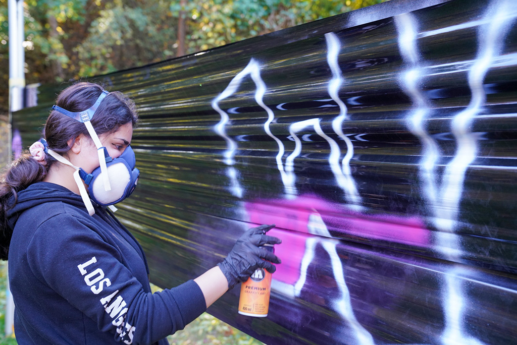 Graffiti Künstlerin beim Sprühen