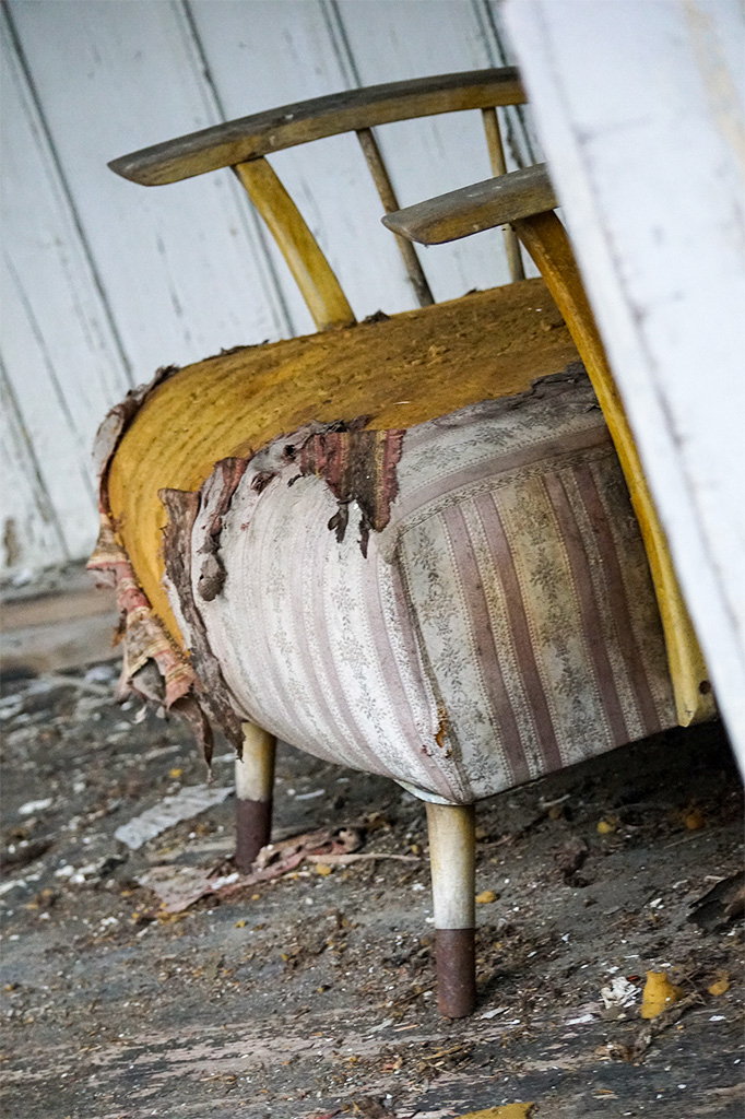 Detailaufnahme: alter Stuhl mit zerfetztem Stoff