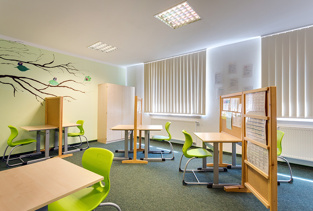 Apfelgrüne Stühle und kleine Schreibtische aus Holz bilden einzelne Lernstationen. Hier werden die die Schüler durch einen Lerncoach begleitet und individuell gefördert.